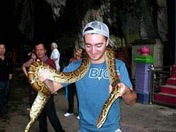 Фото № 232. Застенчивый молодой человек держит змею на шее под присмотром опытного психолога.